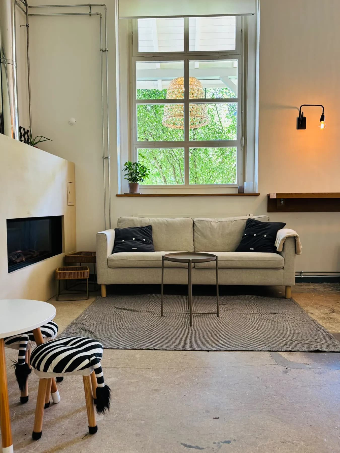 Heller Raum mit Sofa, Fenster und Wandlampe im Kafi Mia
